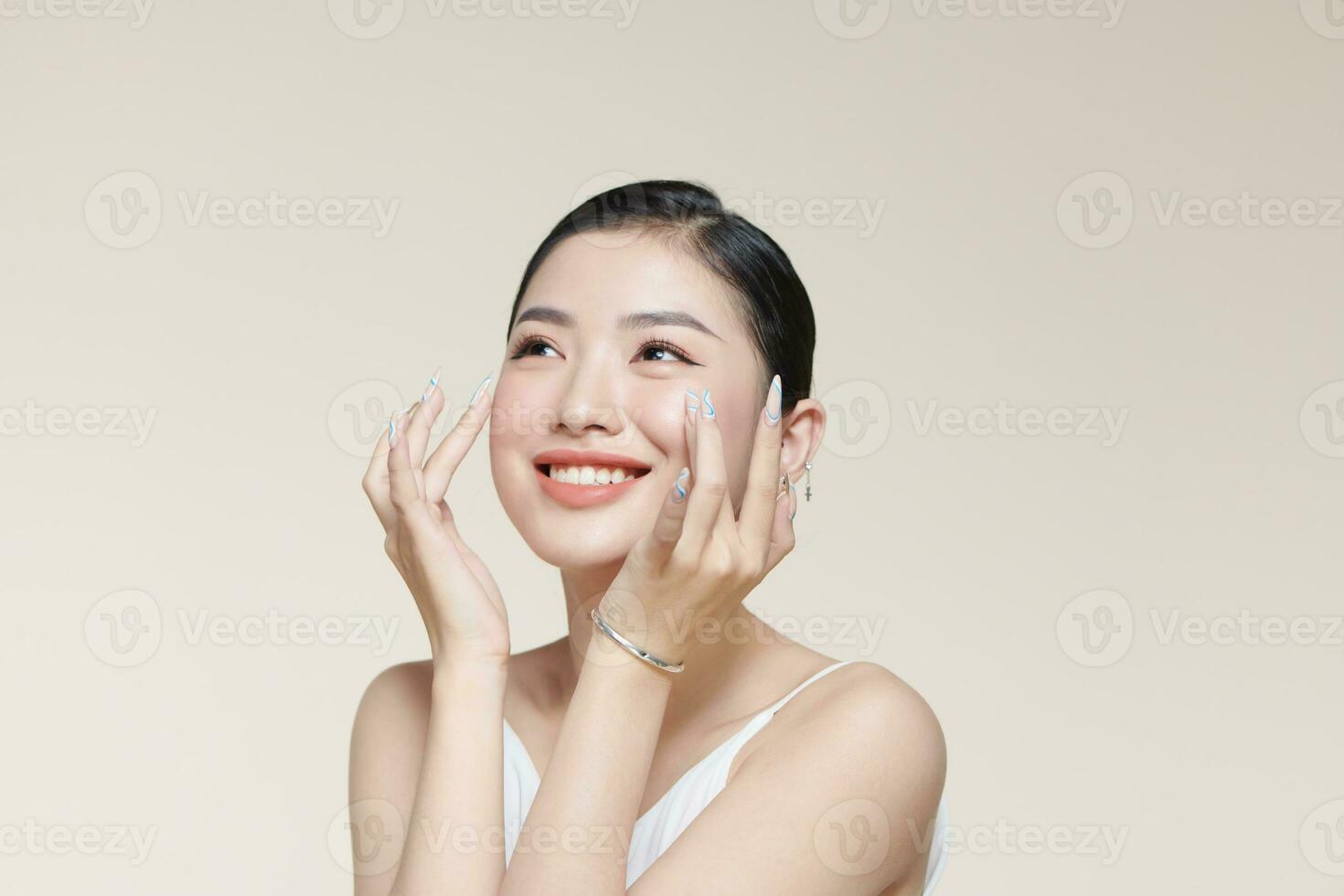 Beautiful young woman with clean fresh skin touching her face photo