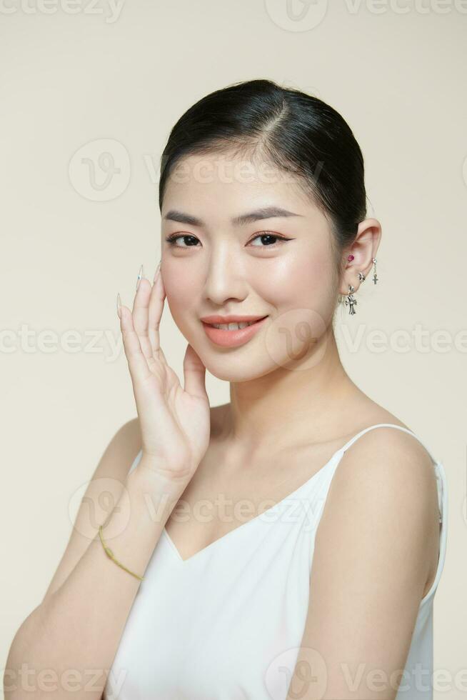Happy young woman face with clear skin on brown background, closeup portrait photo