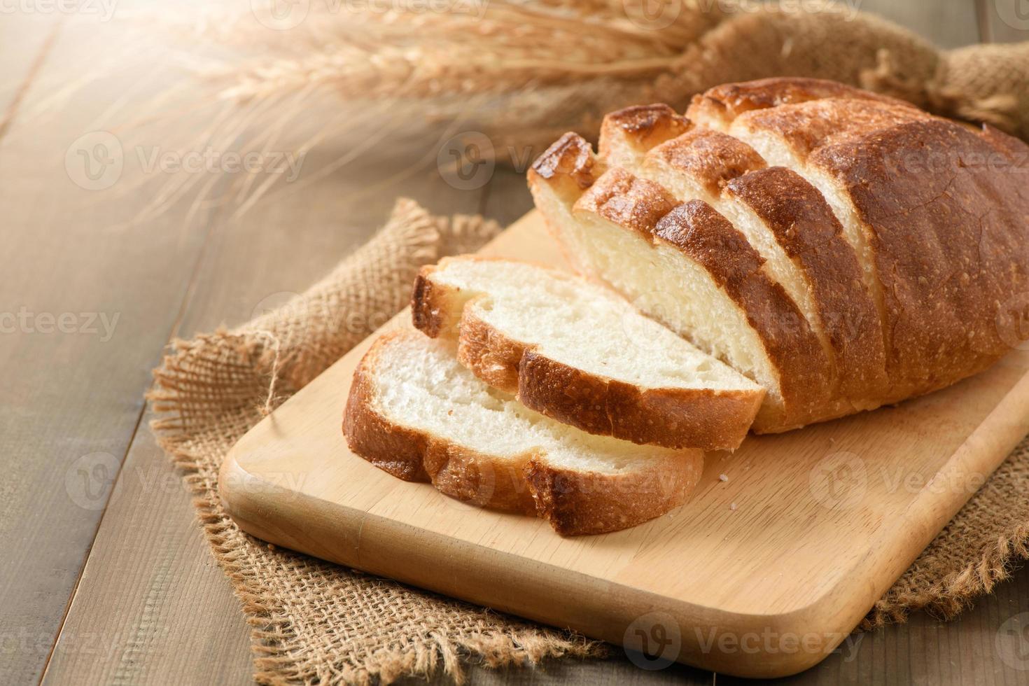 Sliced of fresh homemade french breads on wood background, photo