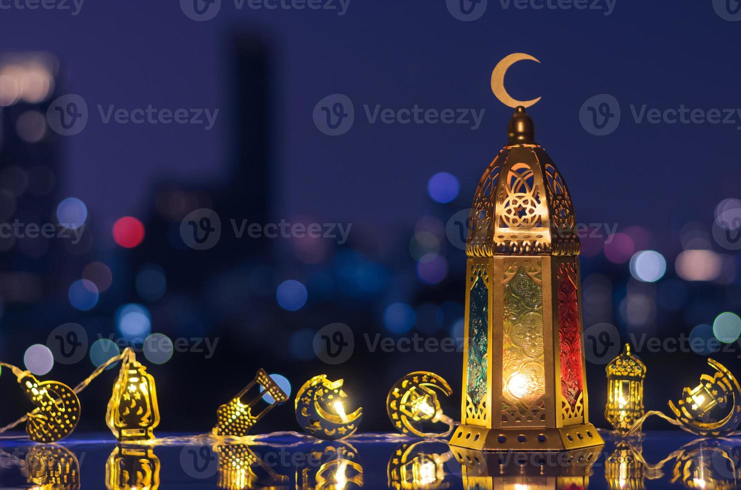 Lantern that have moon symbol on top and decorated light with night sky and city bokeh light background for the Muslim feast of the holy month of Ramadan Kareem. photo
