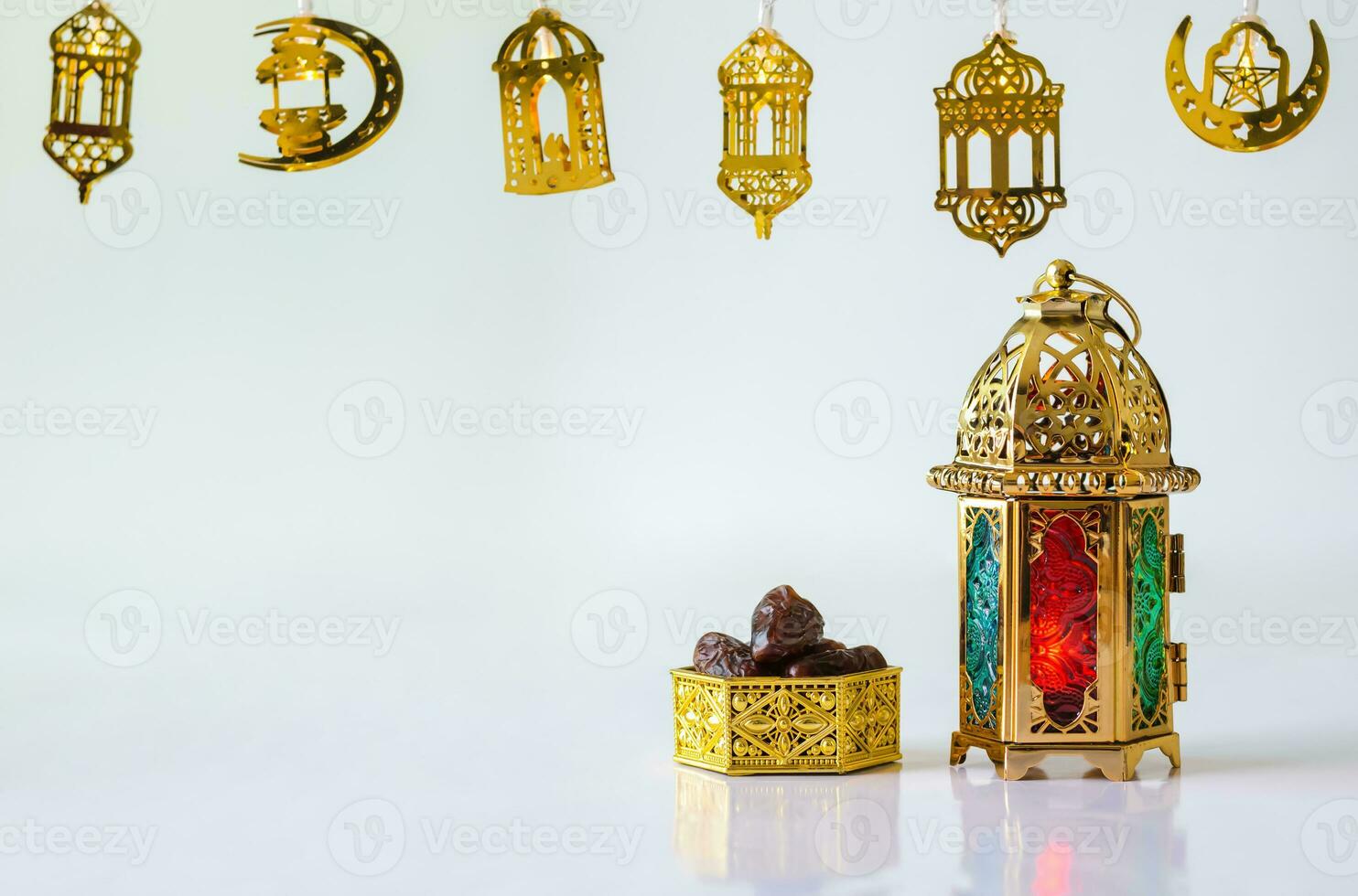 Golden lantern with dates fruit on white background with decorated lights for the Muslim feast of the holy month of Ramadan Kareem. photo