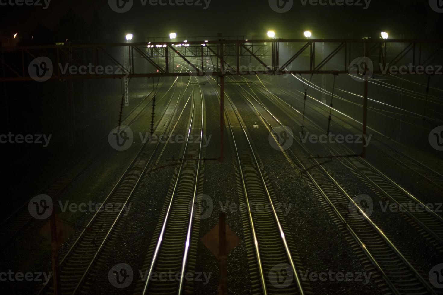 ferrocarril a noche. rieles a estación. muchos pistas para trenes foto