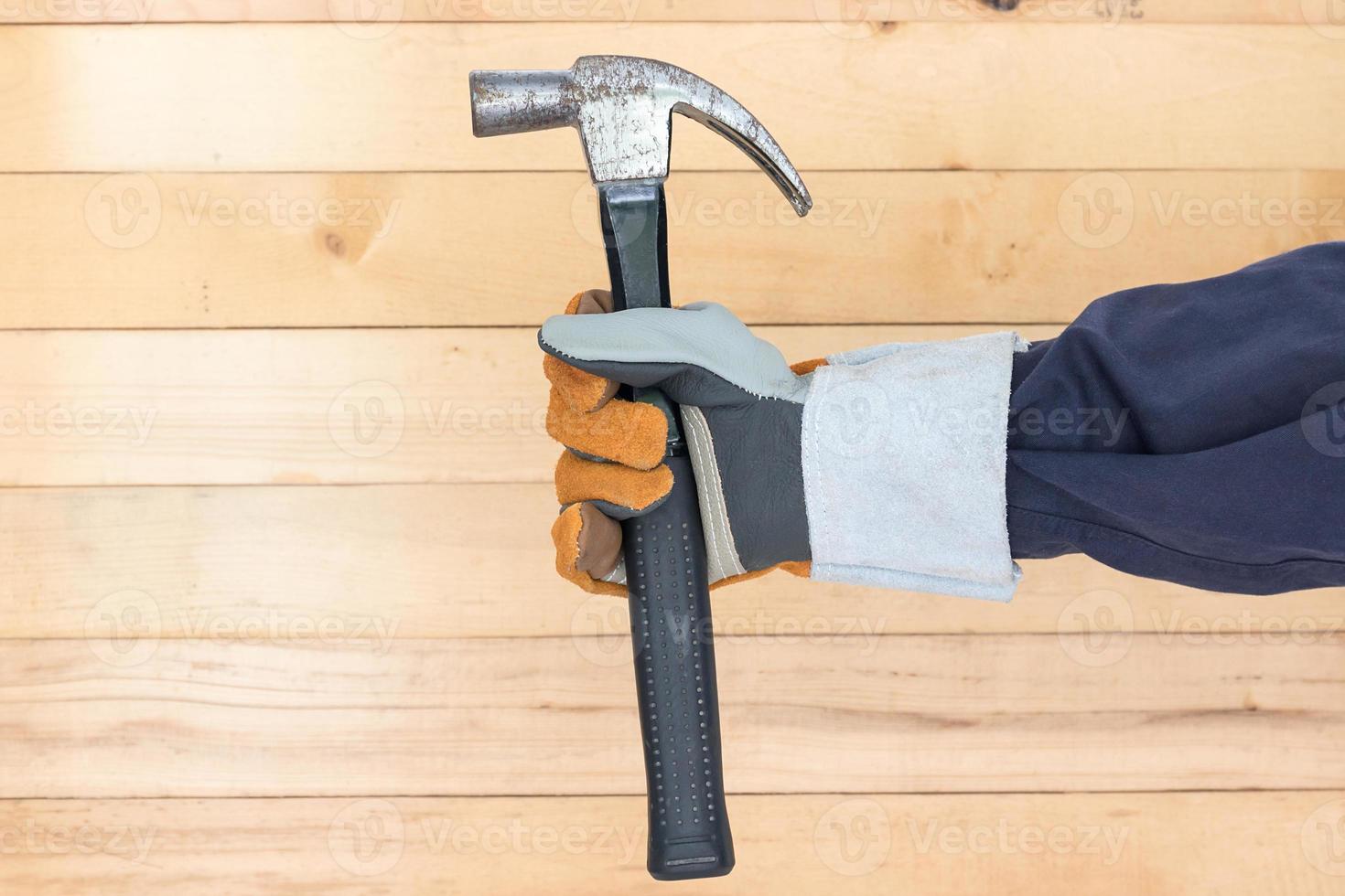 Hand in glove holding hammer photo
