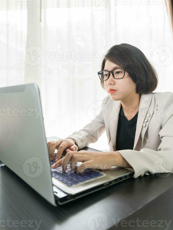 Woman working on laptop in home office photo