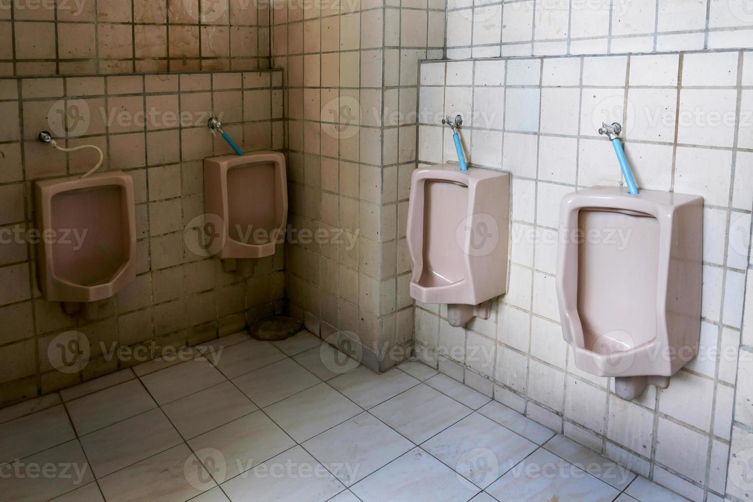 Dirty old bathroom,Interior Public toilet urinals in men toilet bowl is not very clean. photo