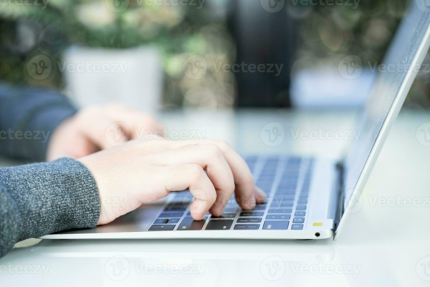 Woman working at home office using laptop searching web, browsing information photo