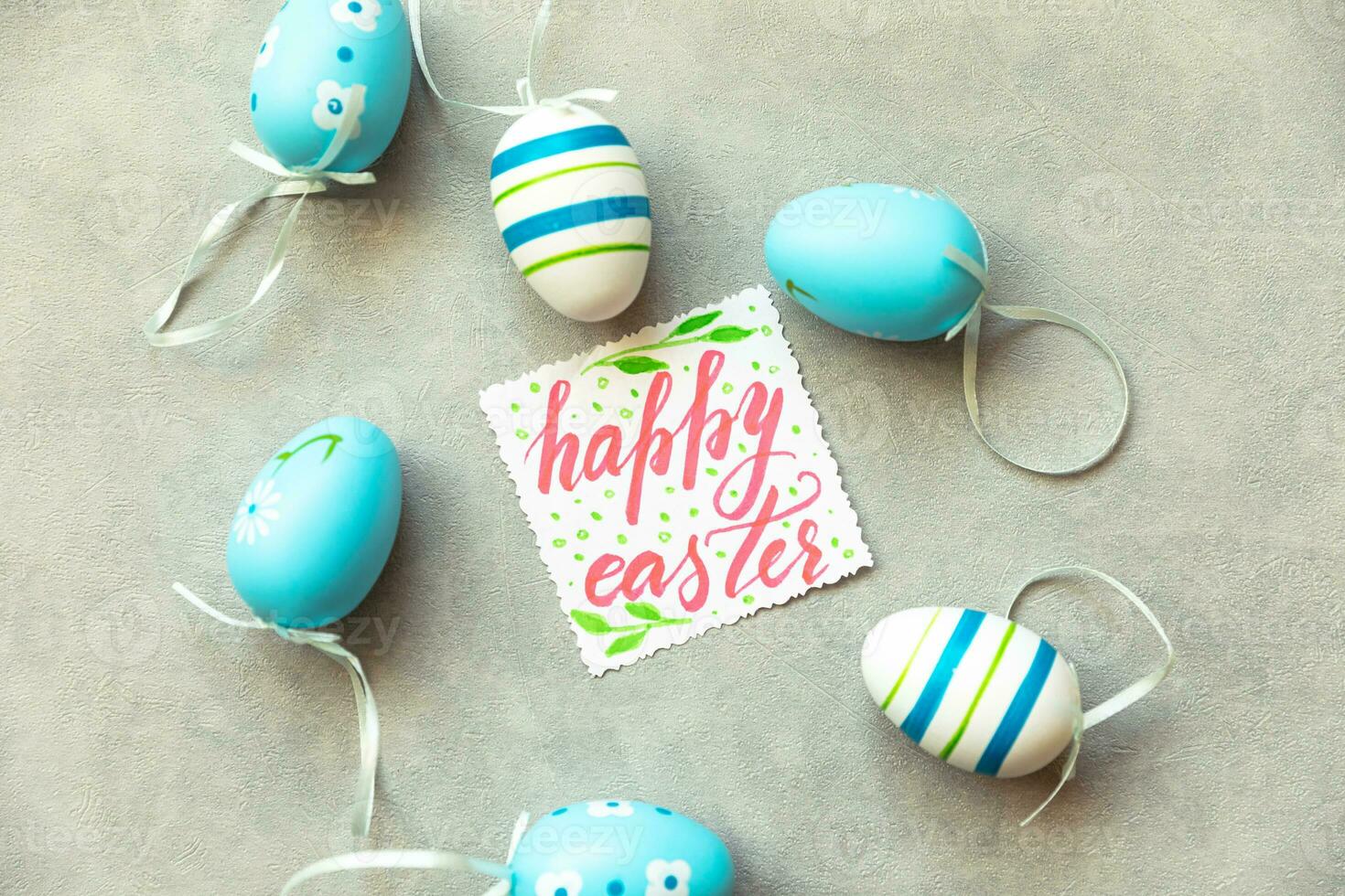 Happy Easter concept. Preparation for holiday. Blue Easter eggs Inscription HAPPY EASTER letters text on concrete stone grey background. Flat lay top view copy space. photo