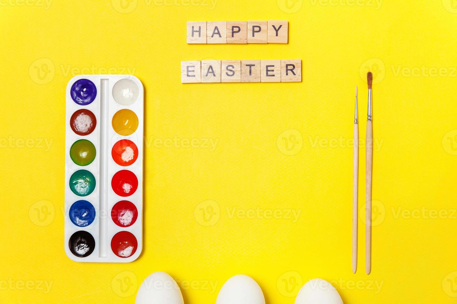 Inscription HAPPY EASTER letters eggs colorful paints isolated on trendy yellow background photo