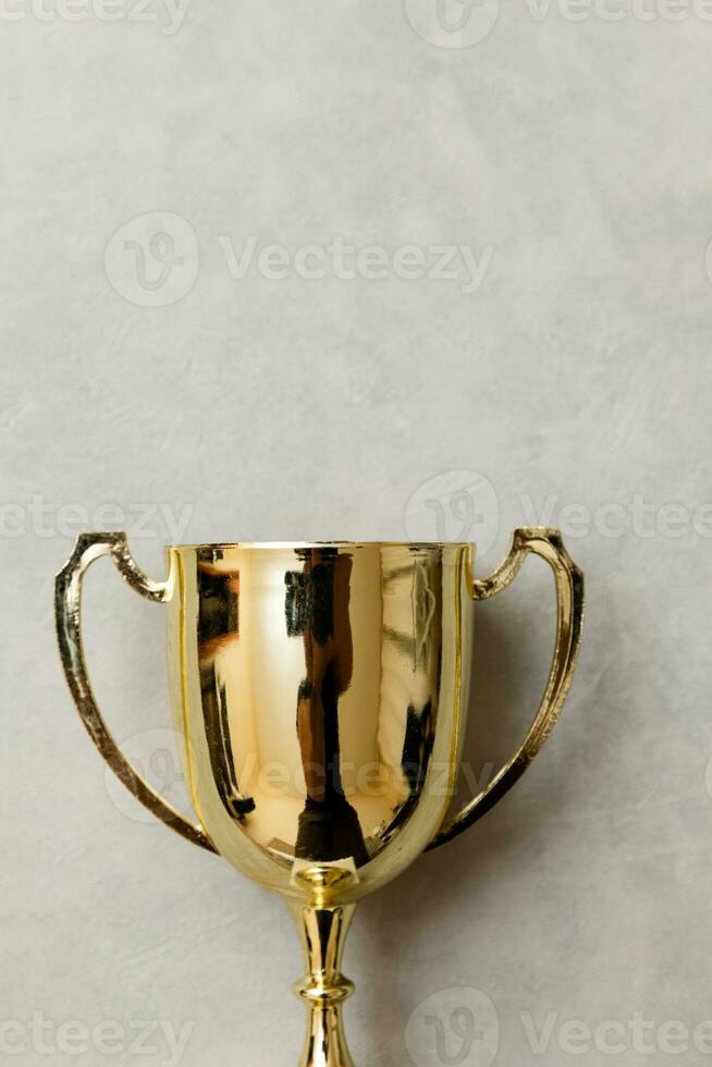 simplemente ganador de diseño plano o campeón de copa de trofeo de oro sobre fondo gris de piedra de hormigón. victoria primer lugar de la competencia. concepto ganador o de éxito. espacio de copia de la vista superior. foto