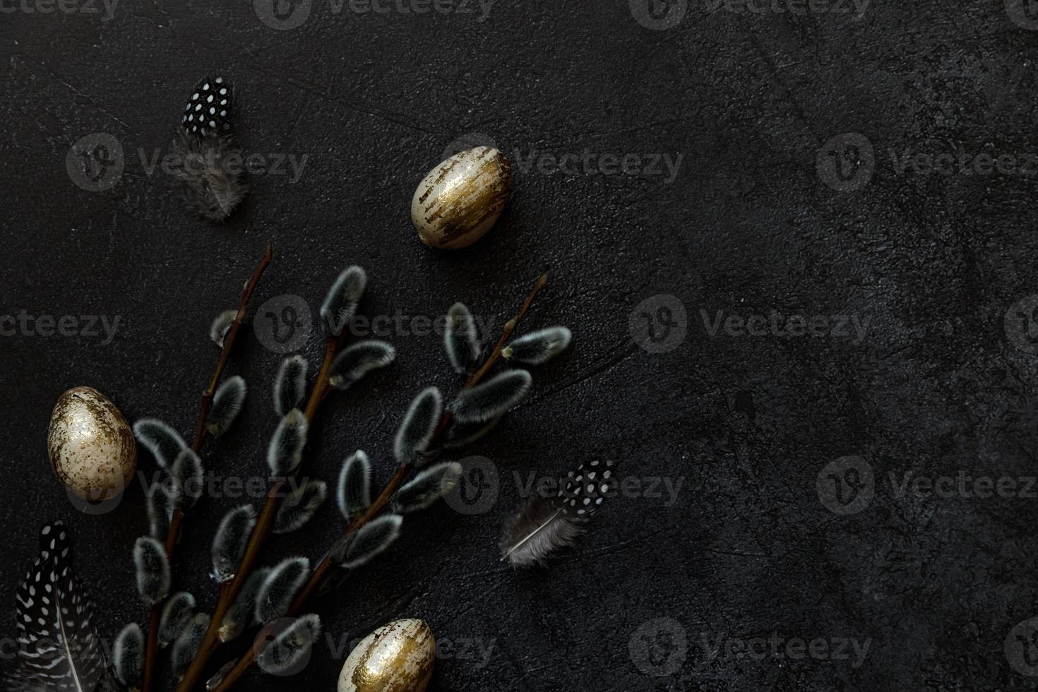 Happy Easter concept. Preparation for holiday. Golden decorated easter eggs willow feather on trendy grunge scratched dark black shale background. Simple minimalism flat lay top view, copy space photo