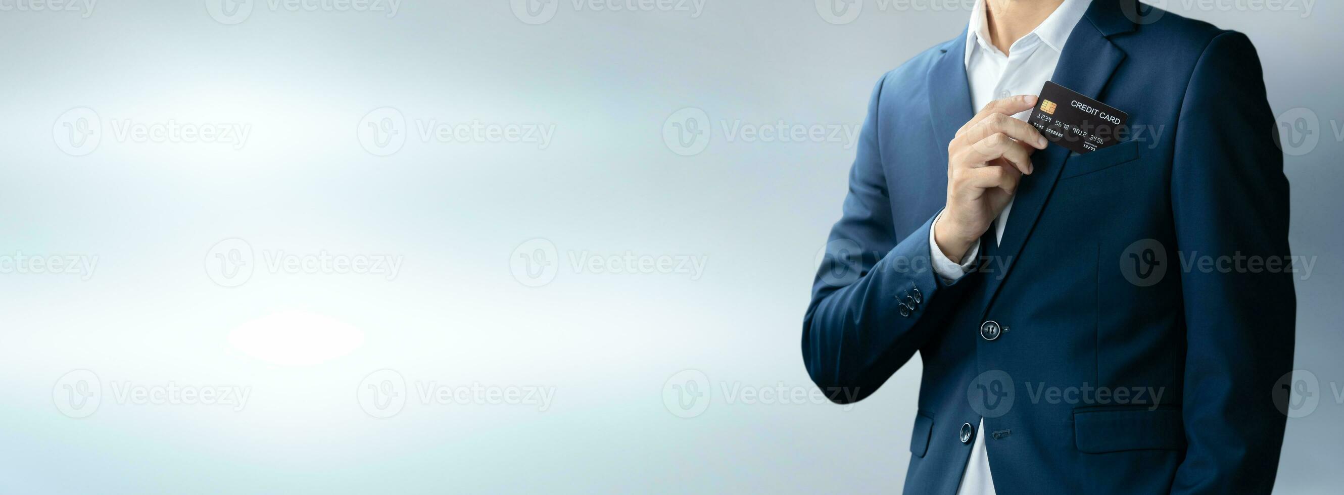 Businessman in blue suit put or take out credit card in pocket with copy space background, Technology digital future of business finance and payment online shopping concept, Handsome young in close up photo