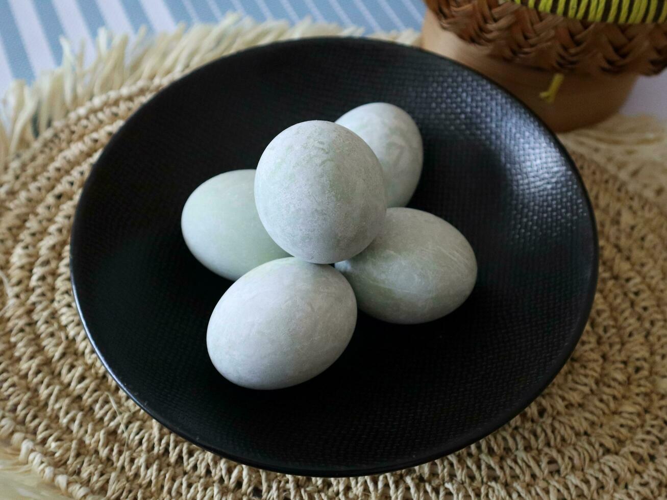 Salted egg in a black plate on a brown textured background photo