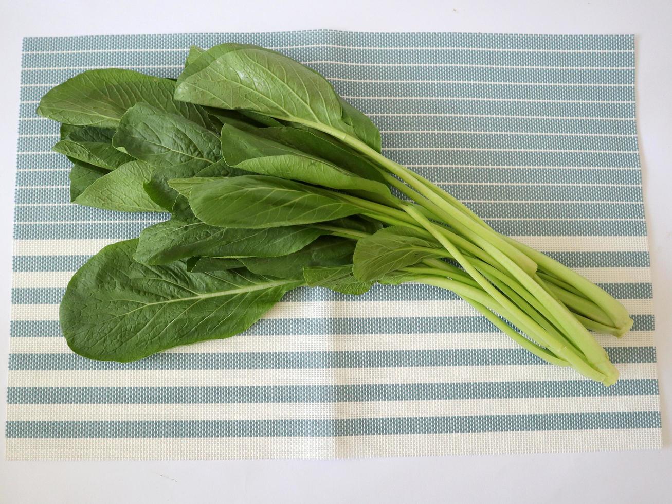 photo of some fresh mustard leaves on a striped cloth. You can use this photo as a background or illustration image