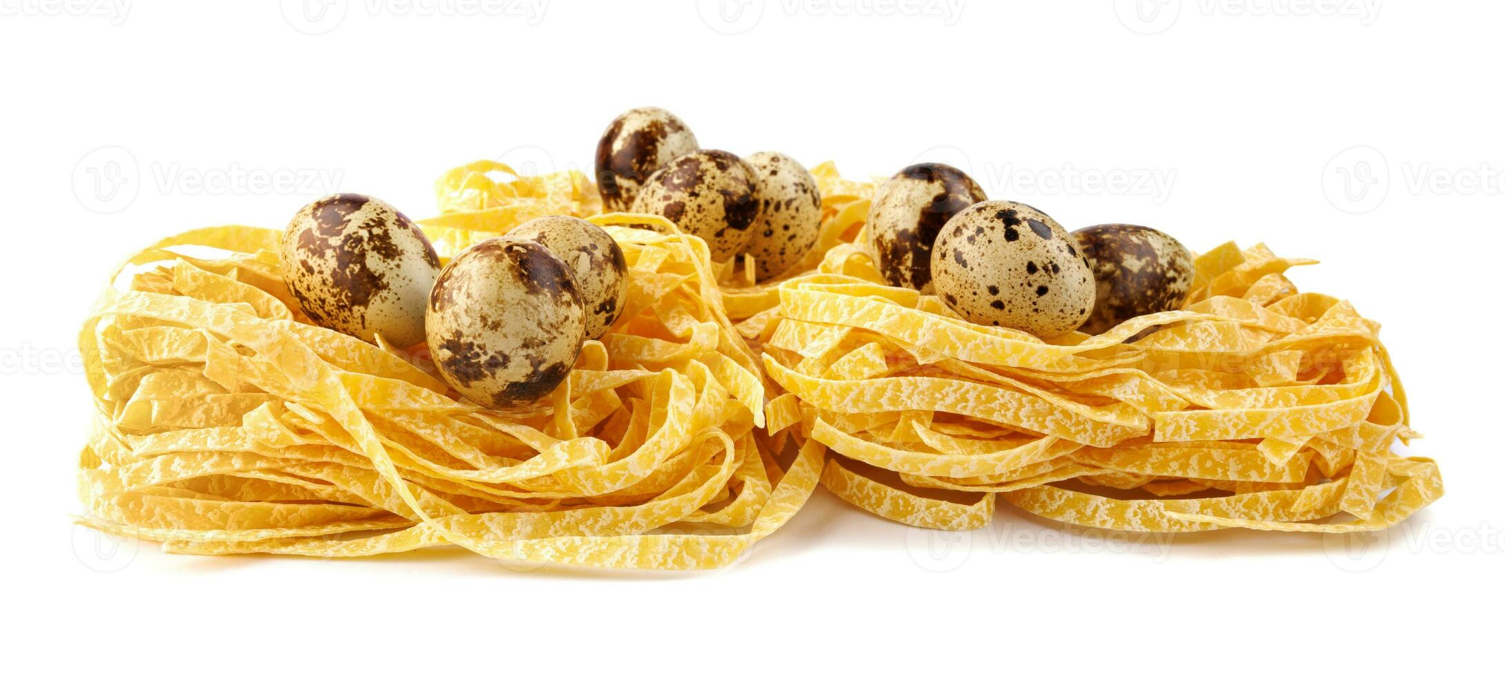 Nests of Italian pasta with quail eggs inside isolated on white background. photo