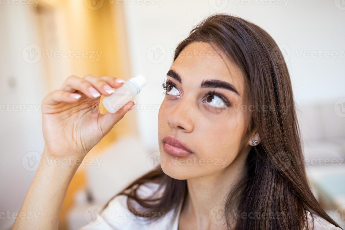 Woman using eye drop, woman dropping eye lubricant to treat dry eye or allergy sick girl treating eyeball irritation or inflammation sick woman suffering from irritated eye, optical symptoms photo