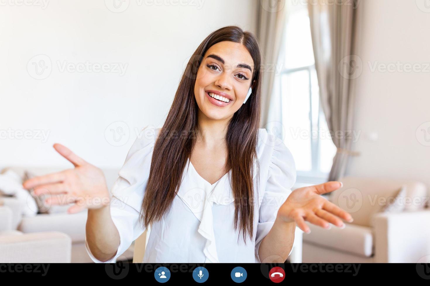 Attractive young woman smiling and looking at camera while having video call. Online teaching. Young woman wearing headphone photo