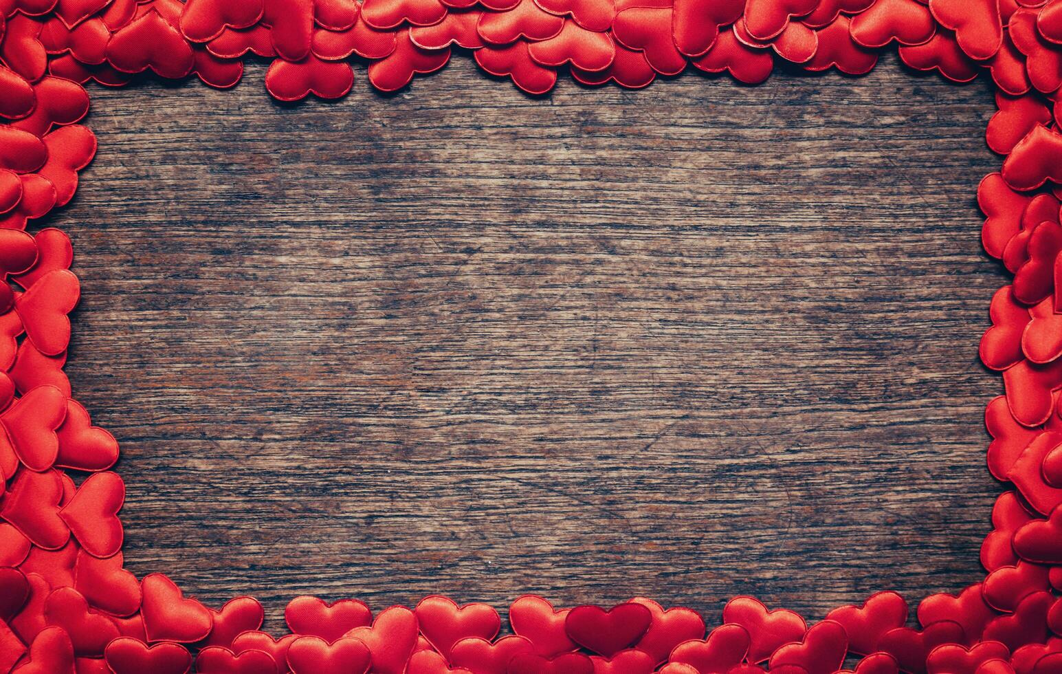 Frame of red heart on wooden background with copyspace. photo