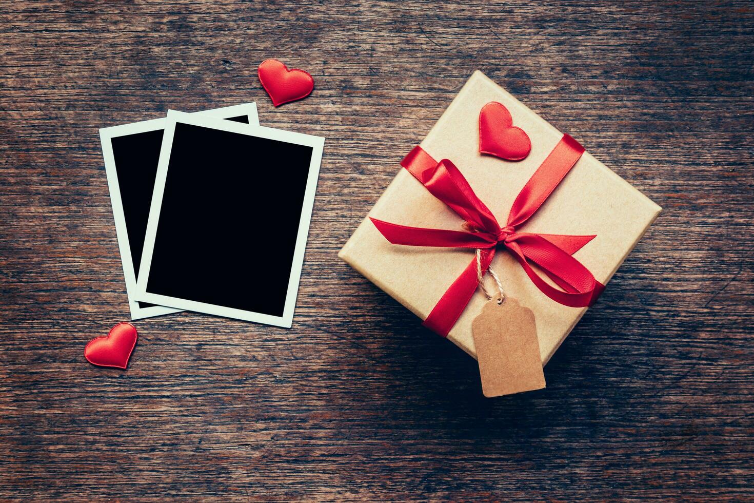 blanco foto marco y regalo caja con rojo corazón en madera antecedentes.