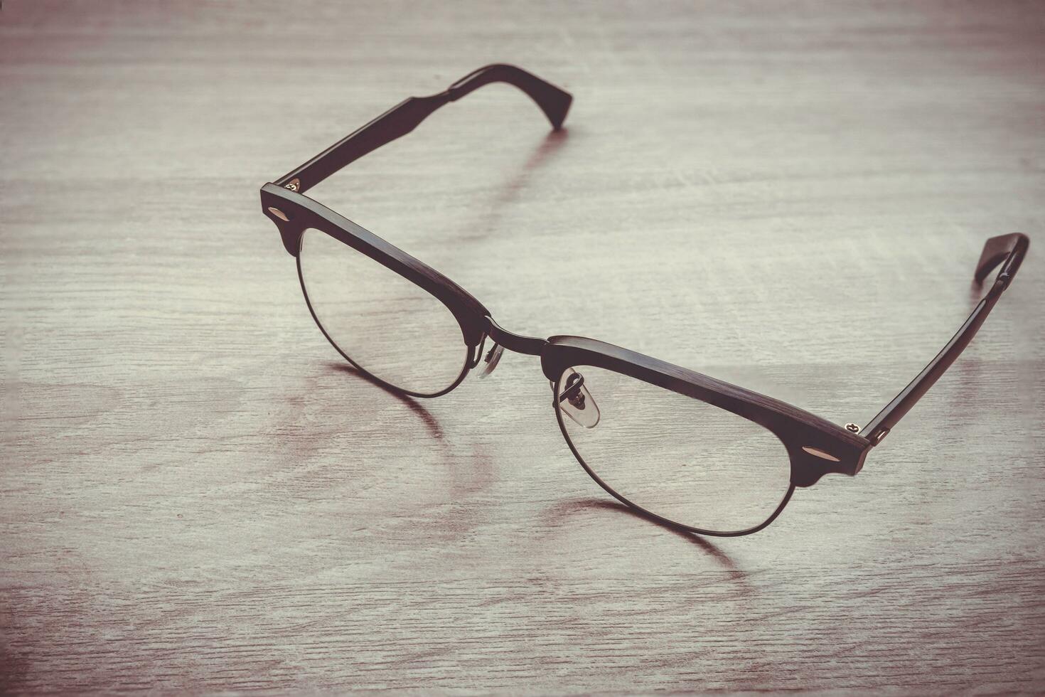 Eyeglasses Glasses with Black Frame Fashion Vintage Style on Wood Desk Background photo