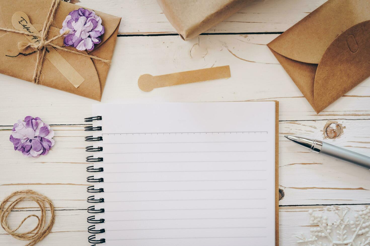 Top view of empty note pad and christmas card on wooden table with xmas decoration. photo
