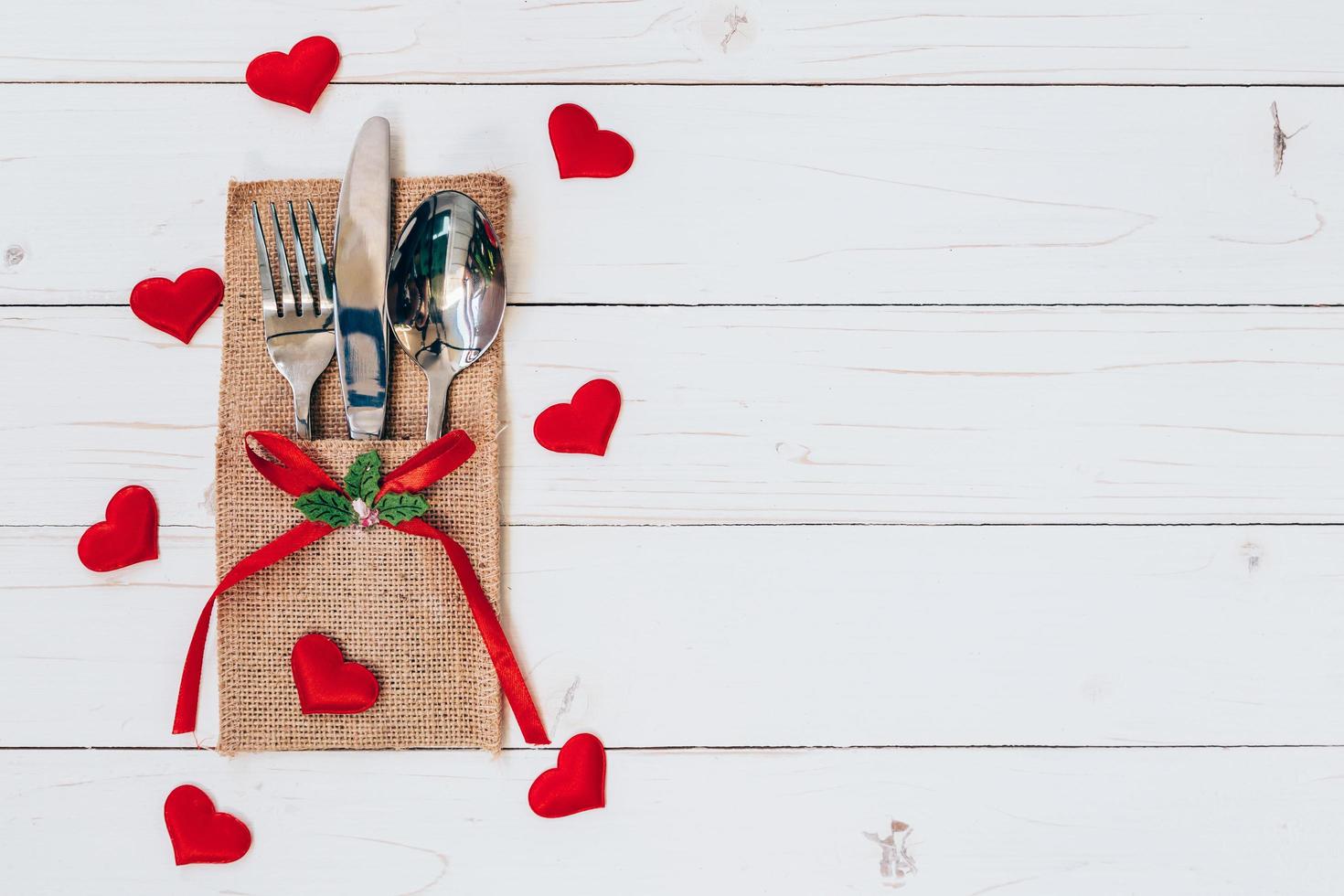 Above wood table set silverware and red heart for valentine day with space. photo