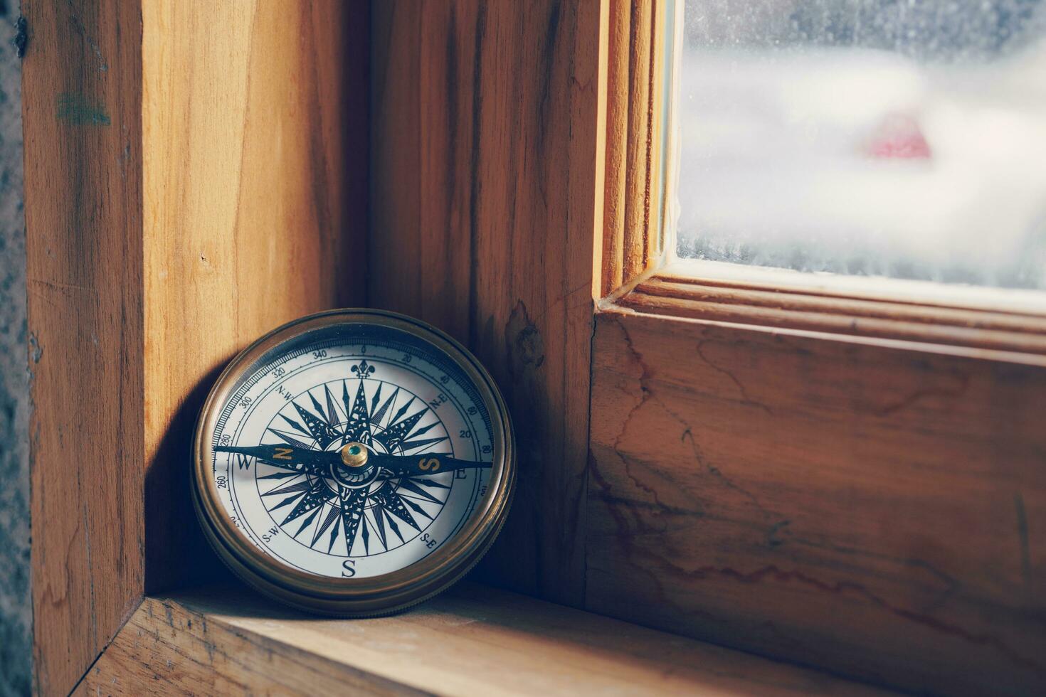 Brújula en de madera ventana para viaje y navegación concepto foto