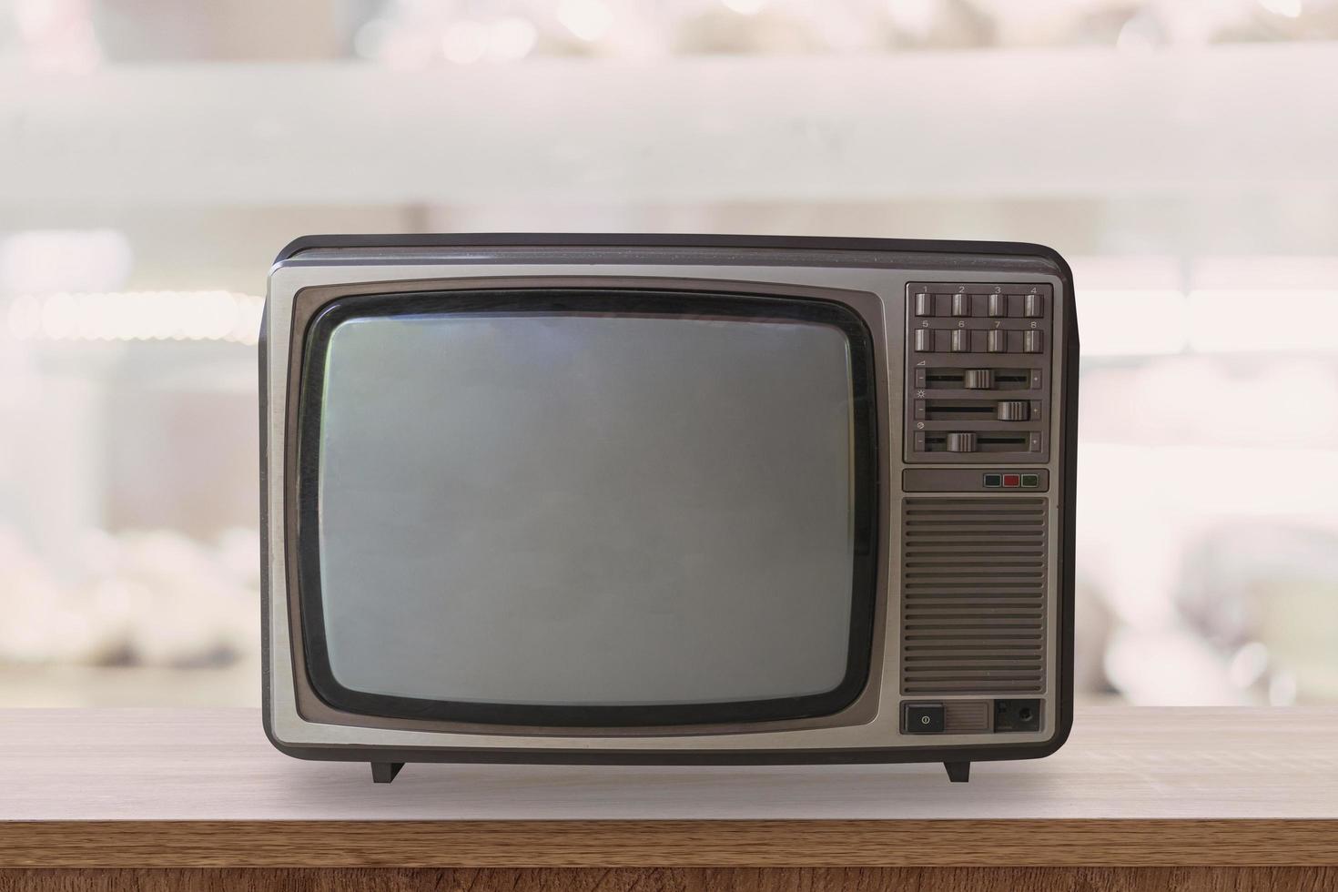 Vintage TV box on wooden table with blur background. photo