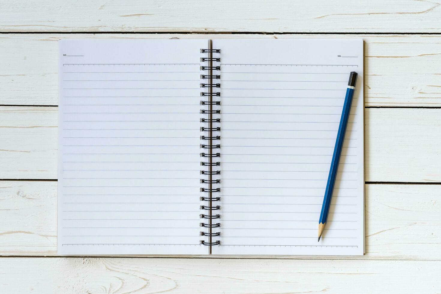 Open notebook with blank pages and pencil on wood table photo