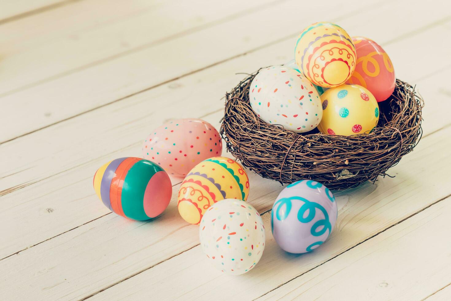 Colorful easter eggs in the nest on wood table background. photo