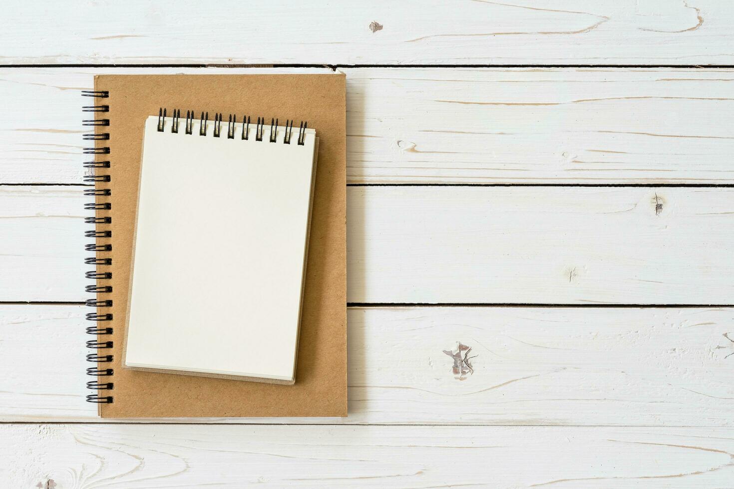 abierto cuaderno con blanco paginas y en madera mesa foto