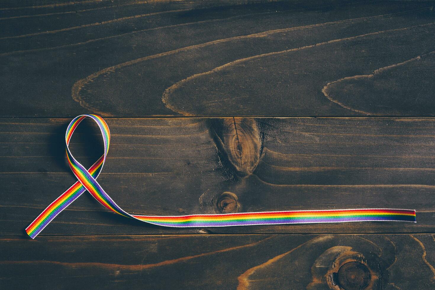 Rainbow ribbon awareness for LGBT concept on wooden background. photo