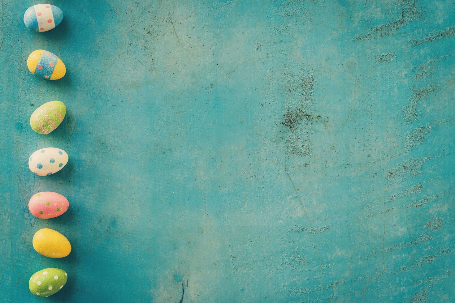 Colorful easter egg on blue pastel color wood background with space. photo