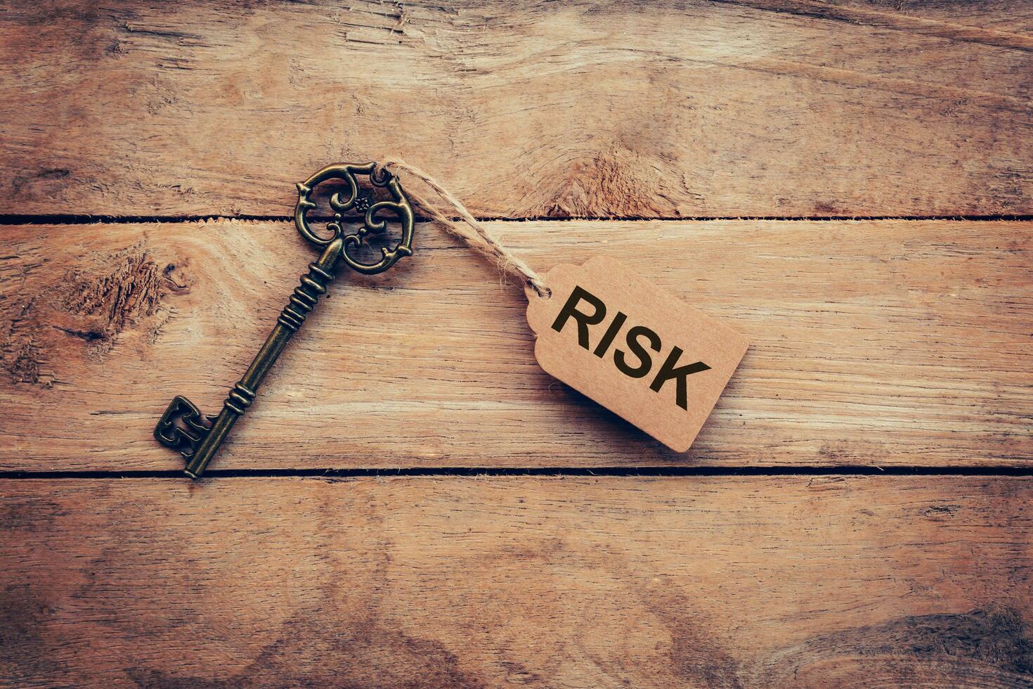 Old key and tag lable RISK for on wooden for business concept. photo
