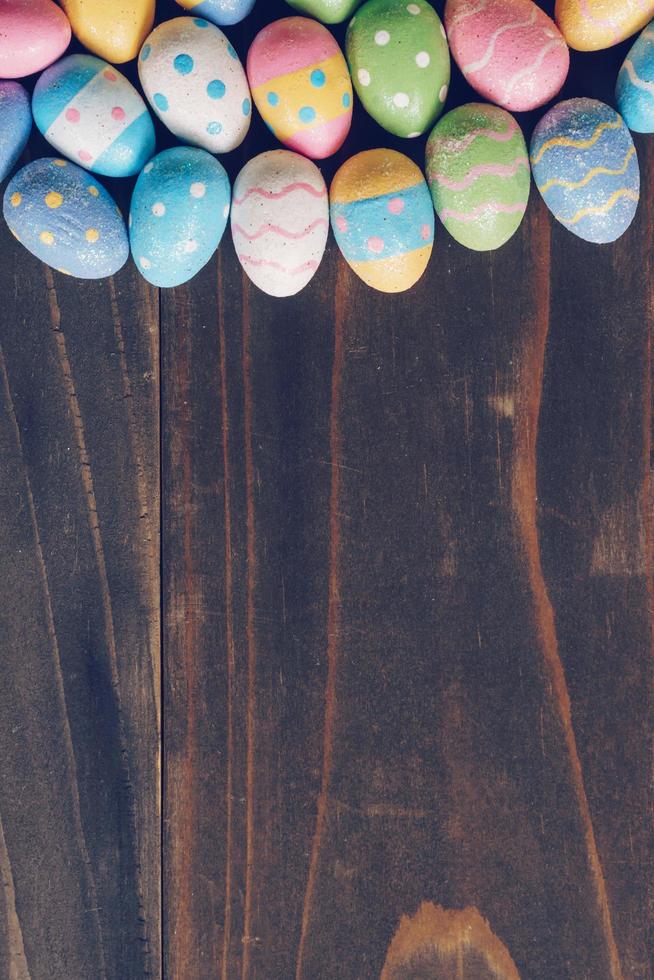 Top view of Easter eggs on rustic wood background vertical with copy space photo