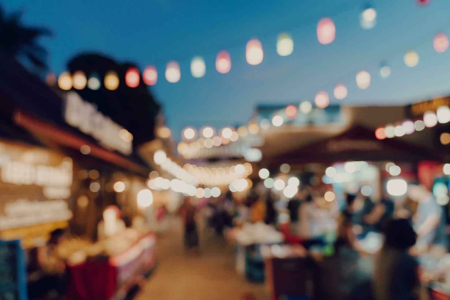 blurred background at night market festival people walking on road. photo