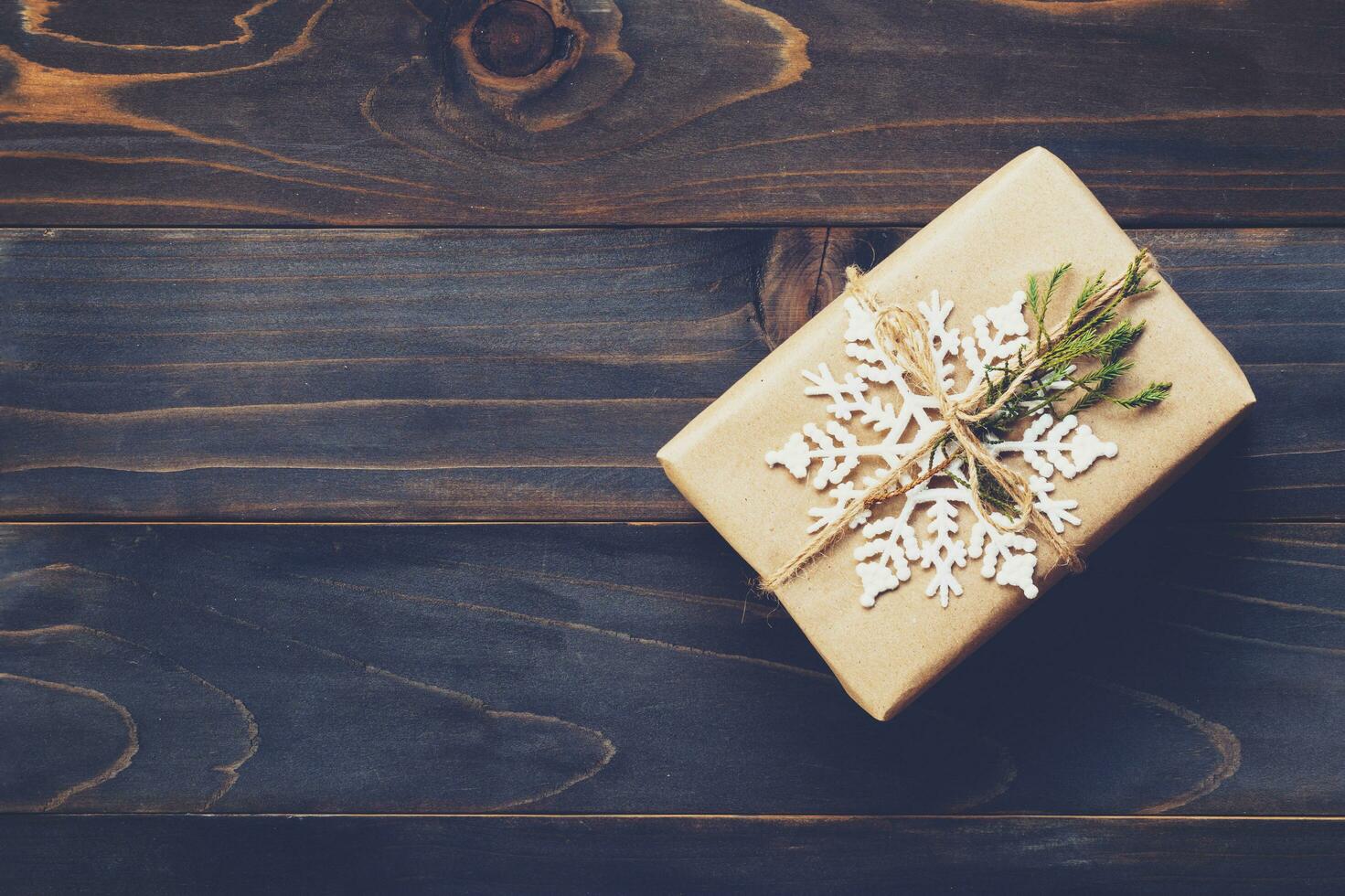 String or twine tied in a bow on kraft paper. Above gift box on wood with space. photo