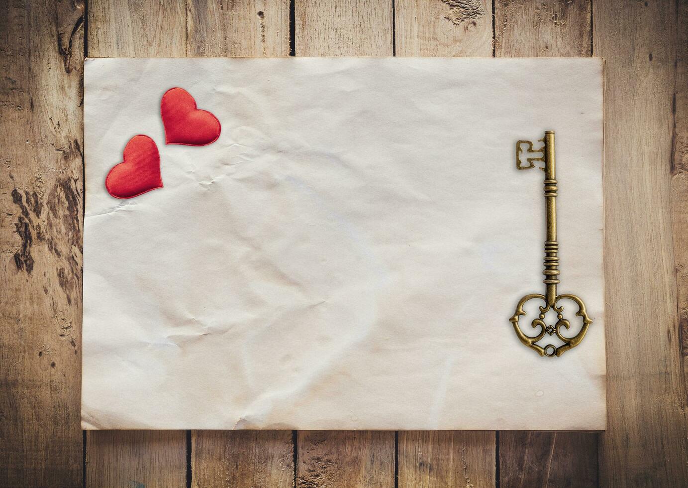 Old key and red heart on Old paper vintage on wood background with space photo