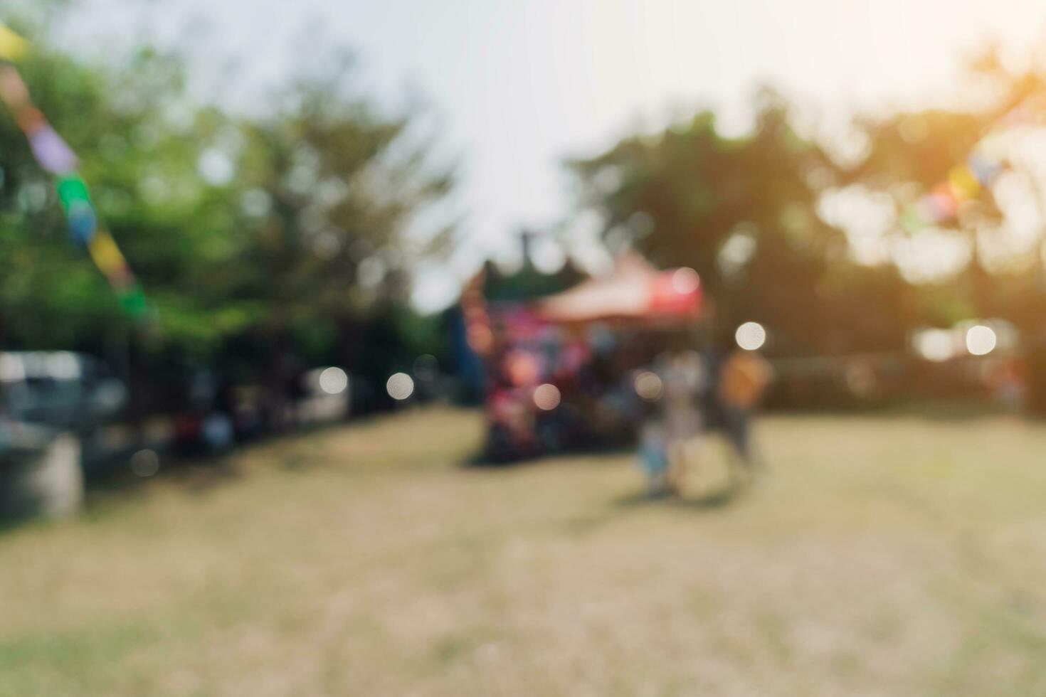 resumen difuminar personas y luz de sol a festival en el ciudad parque jardín con bokeh antecedentes. foto