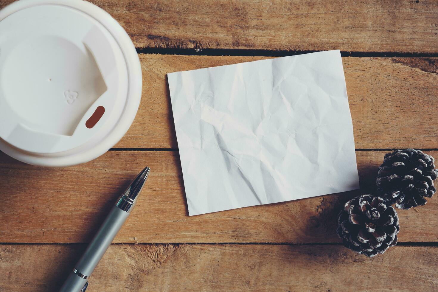 Top view coffee cup and pen, blank paper on wood with christmas decoration for New year concept. photo