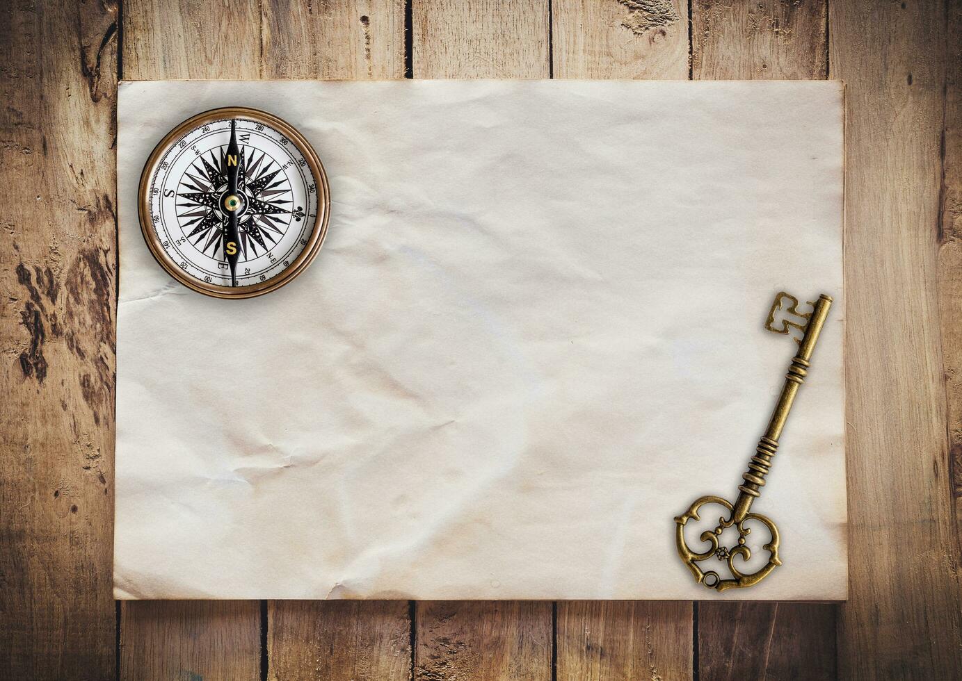 Old key and Compass on Old paper vintage on wood background with space photo