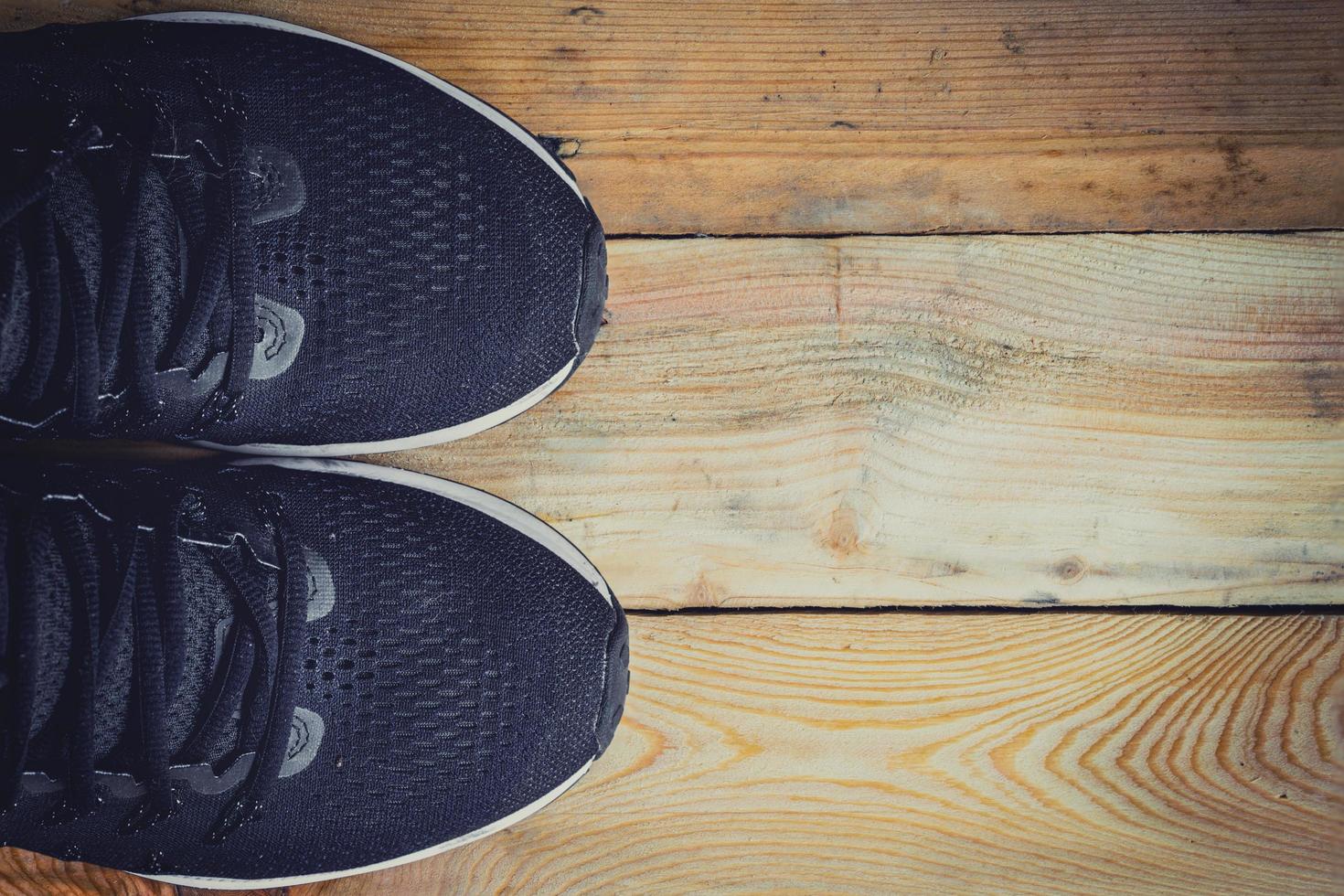 Running shoes on wood background texture with space photo