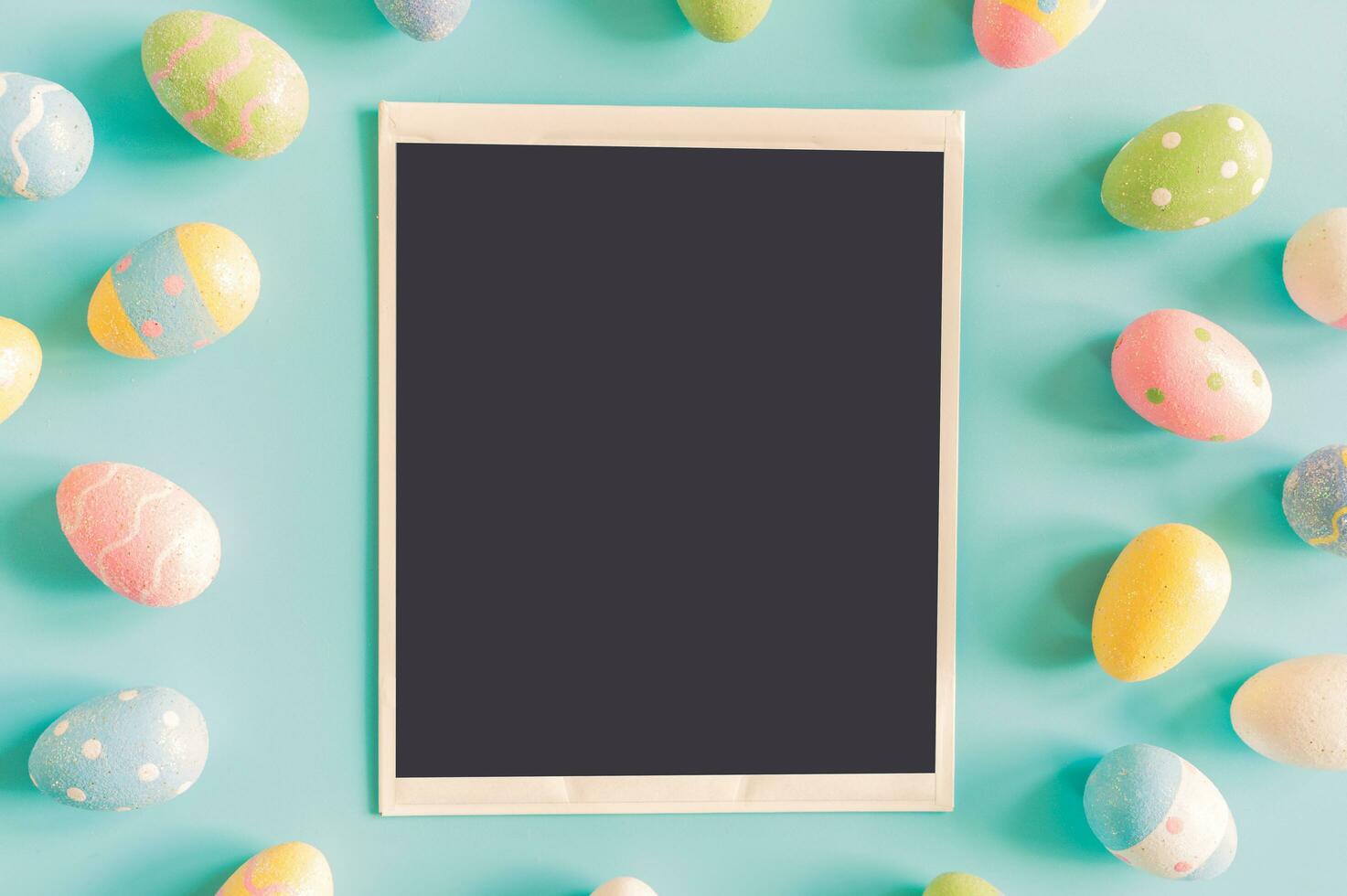 Coloeful easter eggs and instant photo on pastel color background with space.