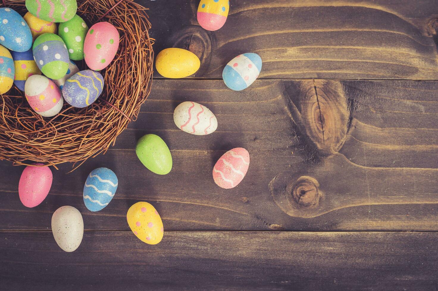 Coloeful easter eggs in neat on plank wooden background with space. photo