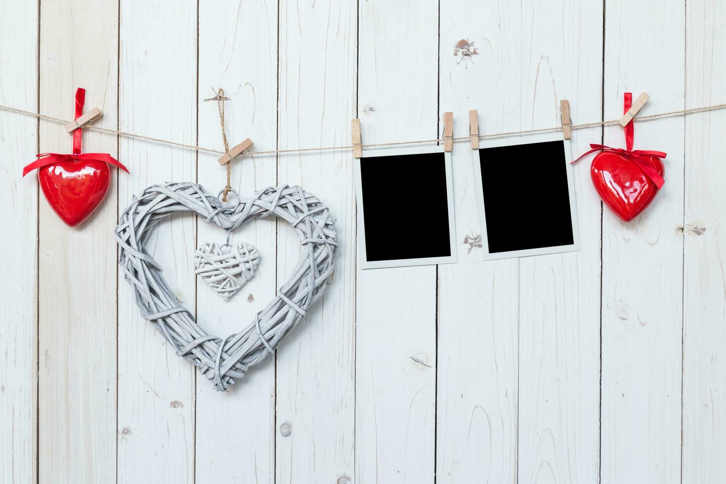 wooden rustic decorative hearts and photo frame hanging on vintage wooden background with space.