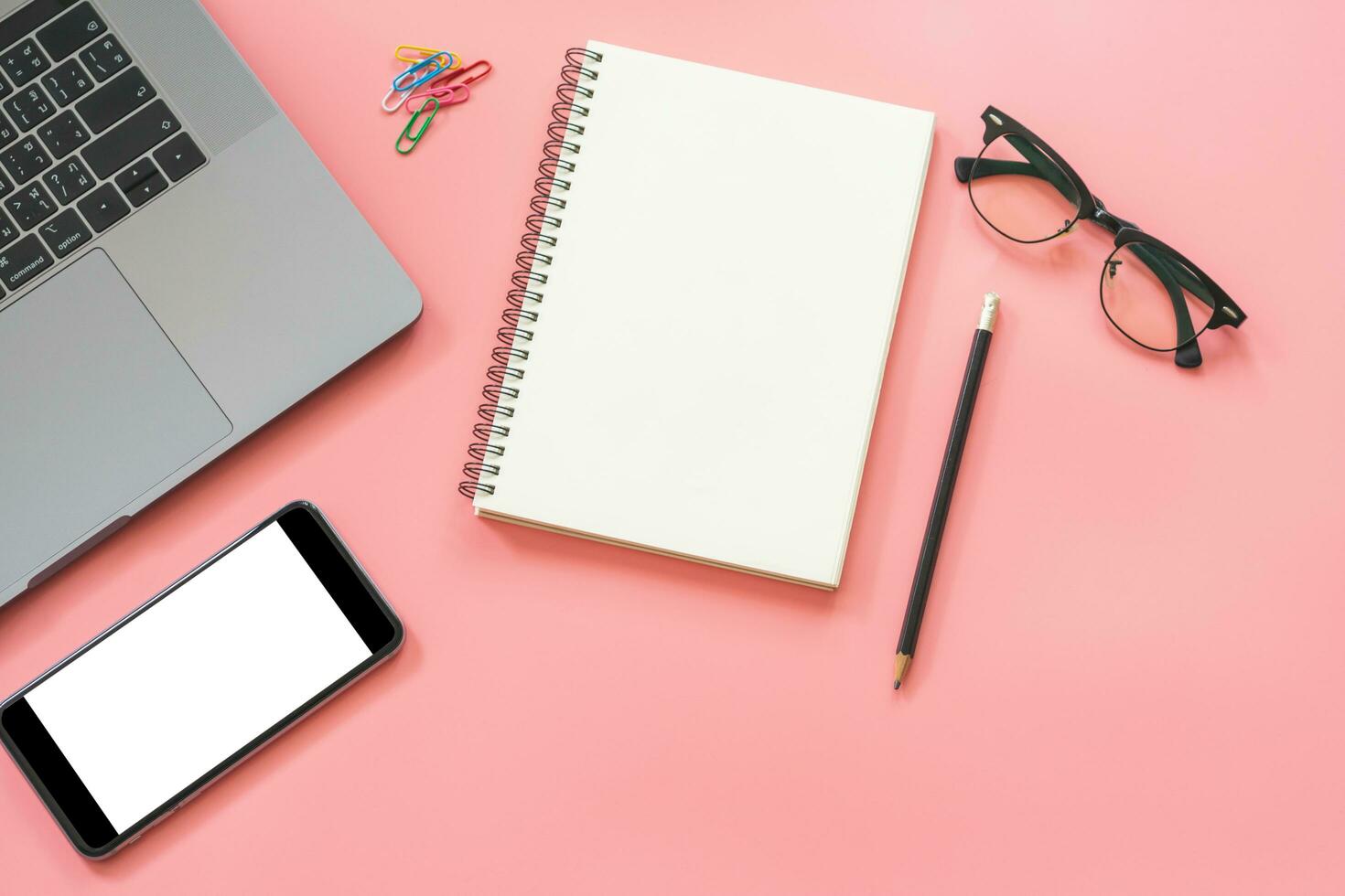 Flat lay design of workspace desk with laptop, blank notebook, smartphone, pencil, stationery with copy space background photo