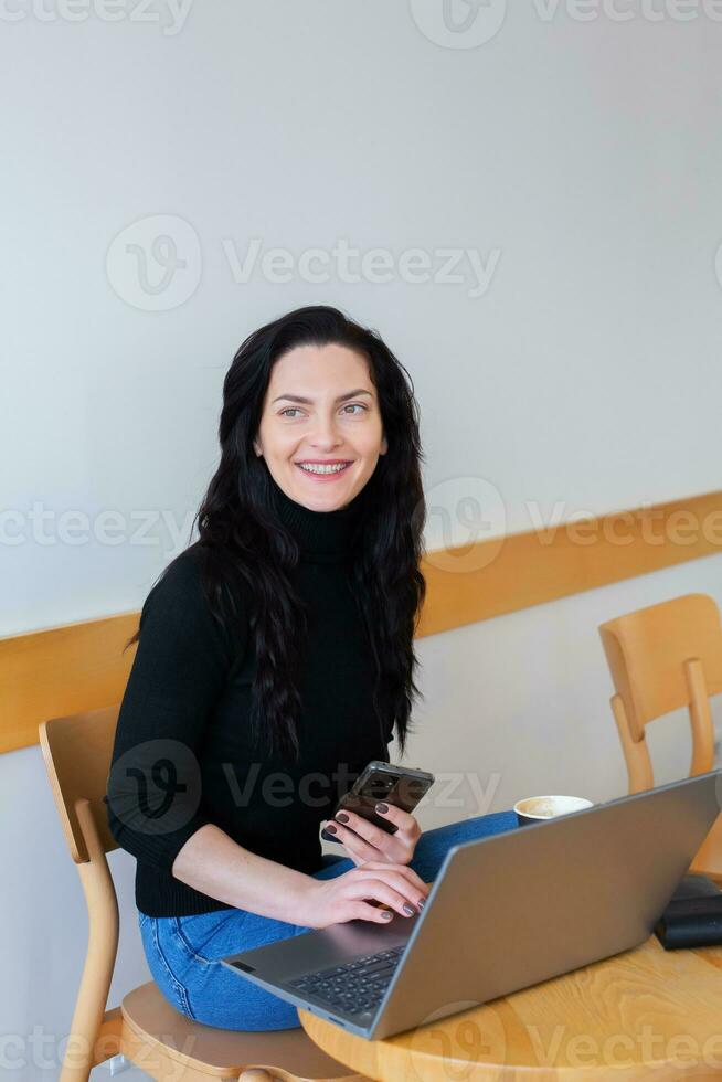 Beautiful businesswoman working on a laptop. Female freelancer connecting to internet via computer. Blogger or journalist writing new article. photo