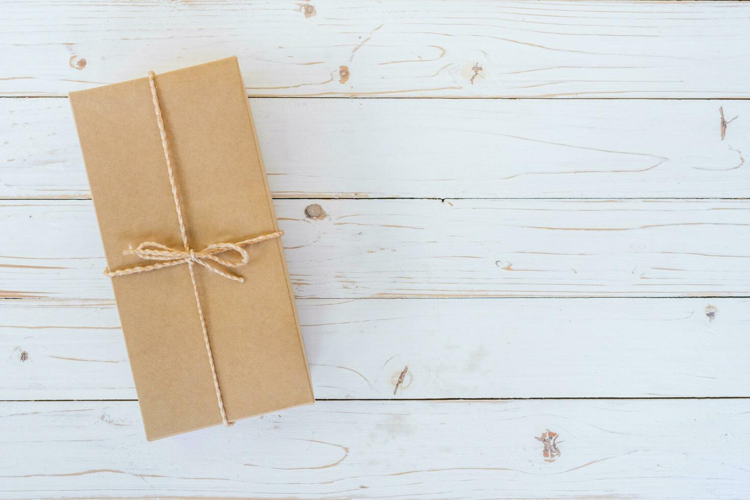 Top view above brown gift box on wooden background with space. photo