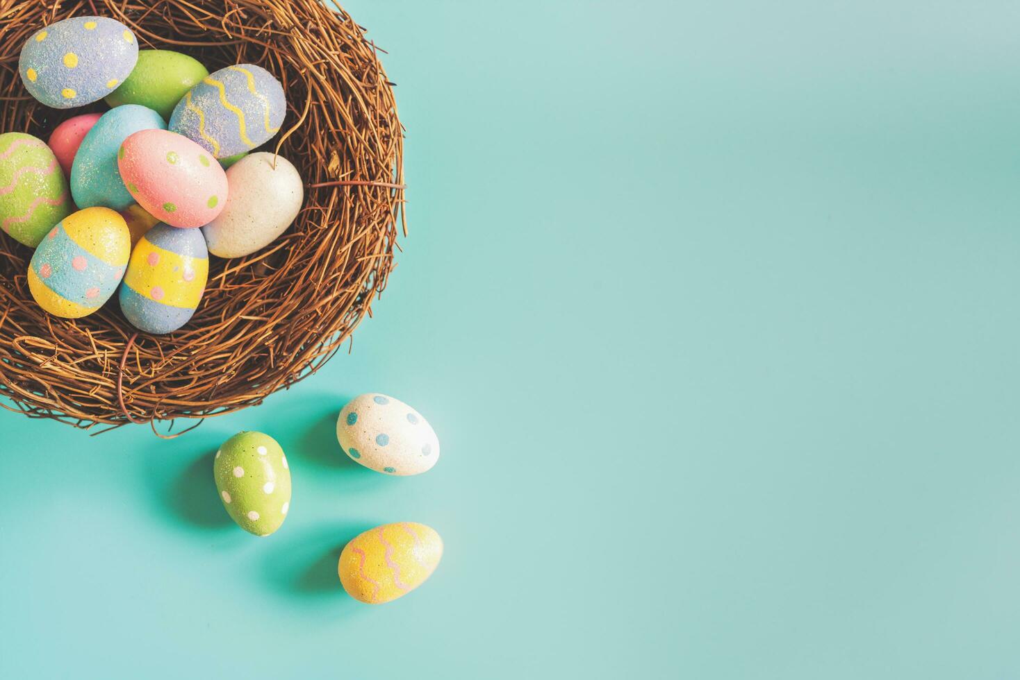 huevos de pascua coloridos en nido sobre fondo de color pastel con espacio. foto