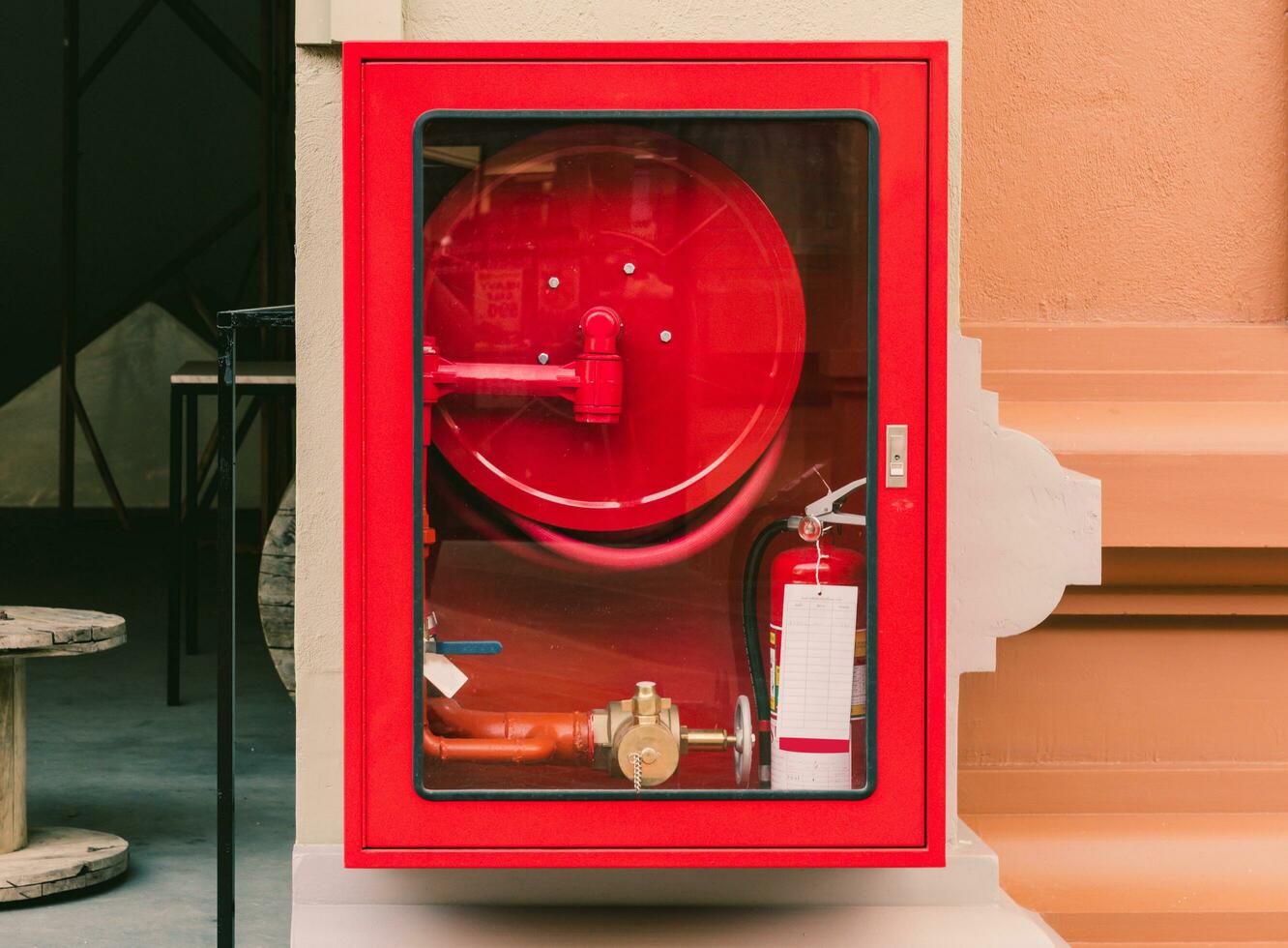 Fire extinguisher and fire hose reel in wall corridor photo