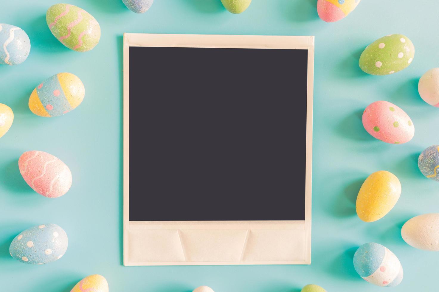 Coloeful easter eggs and instant photo on pastel color background with space.